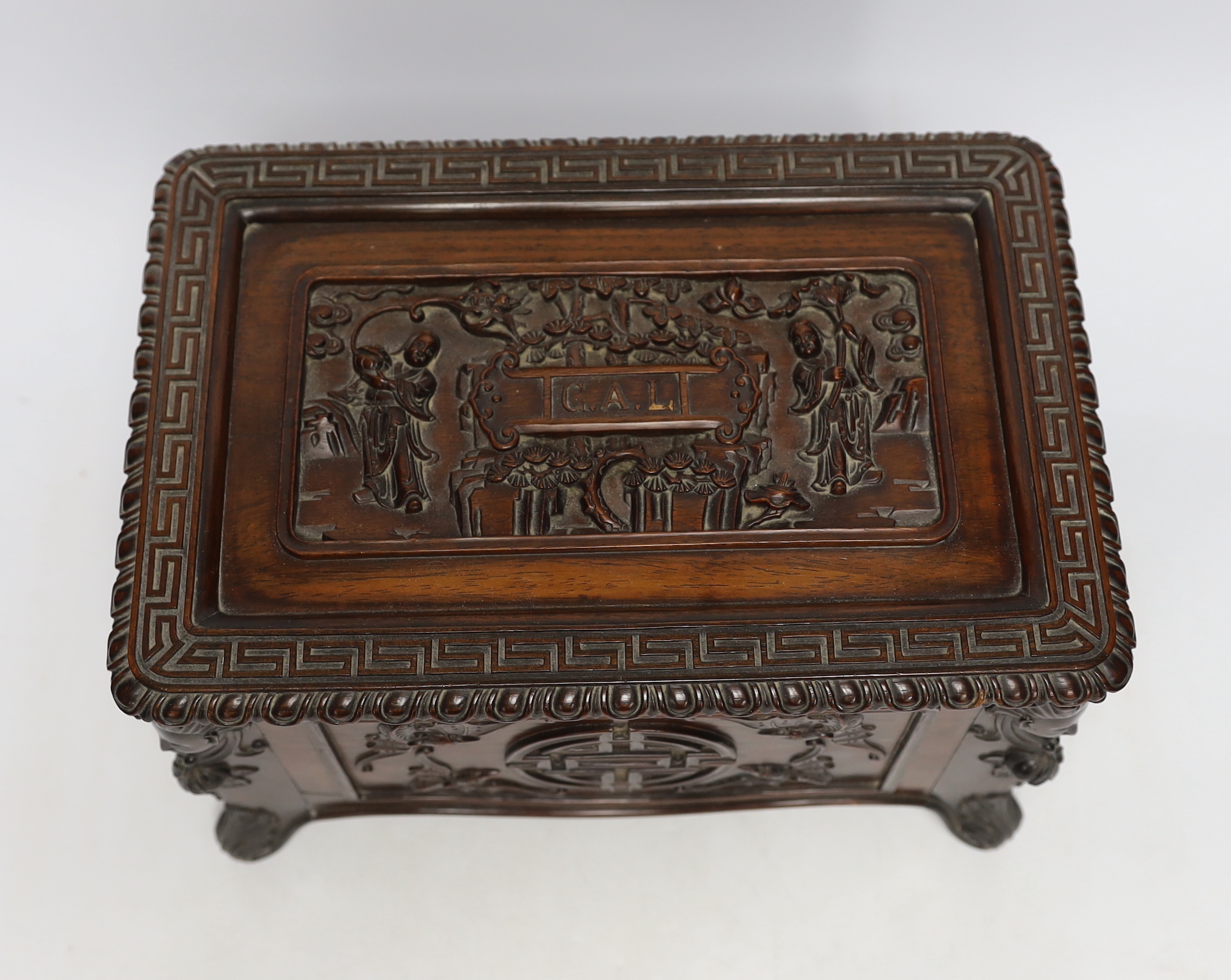 An early 20th century Chinese hongmu wood casket with removable lid and figurative heads on each corner, raised on four feet with G.A.L. carved into the lid, 30cm wide, 20.5cm deep, 20cm high